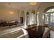 Open-concept living room and dining area with tile floors, large arched windows, and elegant chandeliers at 1695 Horseshoe Rd, Deltona, FL 32725