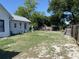 Expansive backyard with scattered greenery and a shed, offering outdoor space and storage potential at 705 Grape Ave, St Cloud, FL 34769