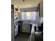 Functional kitchen space with open shelving, neutral tile backsplash, and a window with natural light at 705 Grape Ave, St Cloud, FL 34769