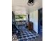 Relaxing covered porch area with patterned rug, seating, and natural light, a perfect outdoor retreat at 705 Grape Ave, St Cloud, FL 34769