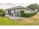 Backyard featuring stone patio, lush green landscaping, seating and grill for outdoor cooking at 9107 Sw 102Nd Cir, Ocala, FL 34481