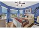 Bedroom boasts natural light from multiple windows, blue walls, and a ceiling fan for added comfort at 9107 Sw 102Nd Cir, Ocala, FL 34481