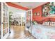 Bedroom view through french doors showing colorful walls, artwork, wood floors, and a glimpse into other rooms at 9107 Sw 102Nd Cir, Ocala, FL 34481