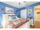 Bright bedroom features blue walls, wood flooring, ceiling fan, and a spacious closet with white doors at 9107 Sw 102Nd Cir, Ocala, FL 34481