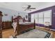 A primary bedroom features a wooden bed frame, ceiling fan, and a large window with white shutters at 9107 Sw 102Nd Cir, Ocala, FL 34481