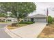 Beautiful home with a gray exterior, lush landscaping, and a spacious driveway at 9107 Sw 102Nd Cir, Ocala, FL 34481