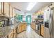 Well-equipped kitchen showcasing wooden cabinetry, granite counters, stainless steel appliances, and a cozy breakfast nook at 9107 Sw 102Nd Cir, Ocala, FL 34481