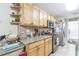 Galley kitchen featuring light wood cabinets, granite countertops, and stainless steel appliances for a modern cooking experience at 9107 Sw 102Nd Cir, Ocala, FL 34481