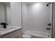 Modern bathroom featuring white subway tile, shower-tub combo, and luxury vinyl plank flooring at 991 Polk St, Bartow, FL 33830
