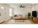 Bright living room with neutral decor, ceiling fan, a large window, and vinyl floors at 991 Polk St, Bartow, FL 33830