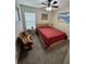 Cozy bedroom featuring a comfortable bed, ceiling fan, and natural light from the window at 10470 Sw 132Nd Ct, Dunnellon, FL 34432