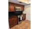Modern kitchen featuring stainless steel appliances and rich wood cabinetry at 211 Crown Oaks Way, Longwood, FL 32779
