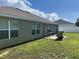 Exterior shot of a backyard with a patio and small charcoal grill and green grass at 31517 Broadwater Ave, Leesburg, FL 34748