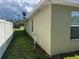 Exterior shot of a yard with a gray home with green grass and a privacy fence at 31517 Broadwater Ave, Leesburg, FL 34748
