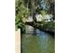 Beautiful backyard with a canal, lush green grass, and patio seating near a white home at 690 Osceola Ave # 405, Winter Park, FL 32789