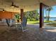 Covered patio with table seating, brick floors, and views of lawn and a lake at 690 Osceola Ave # 405, Winter Park, FL 32789