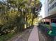 Brick walkway adjacent to condos and a wooded area with creek and bench at 690 Osceola Ave # 405, Winter Park, FL 32789