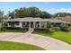 Charming home featuring a landscaped front yard, covered porch and a circular driveway at 1410 Poinsettia Ave, Orlando, FL 32804