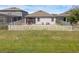 Fenced backyard featuring a white fence, patio, seating, manicured lawn, and a view of the home's exterior at 1896 Napoli Dr, St Cloud, FL 34771
