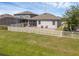 Fenced backyard featuring a white fence, patio, seating, manicured lawn, and a view of the home's exterior at 1896 Napoli Dr, St Cloud, FL 34771
