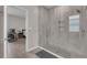 Modern bathroom features a walk-in shower with gray tiling and glass doors and niche shelving with view of bedroom at 1896 Napoli Dr, St Cloud, FL 34771