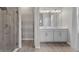 Bright bathroom features a double vanity with white cabinets and accent tiling and wood look floors at 1896 Napoli Dr, St Cloud, FL 34771