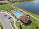 Aerial view of the community pool featuring lounge chairs, parking, and landscaping near the lake at 1896 Napoli Dr, St Cloud, FL 34771