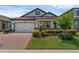 Inviting home with a brick driveway and verdant landscaping providing attractive curb appeal at 1896 Napoli Dr, St Cloud, FL 34771