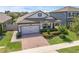 Charming home showcasing a brick driveway, manicured lawn, and lovely landscaping at 1896 Napoli Dr, St Cloud, FL 34771