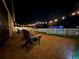 Paver patio with string lights illuminating the seating area and fenced backyard at night at 1896 Napoli Dr, St Cloud, FL 34771