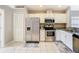 Bright kitchen with stainless steel appliances, tile flooring, granite countertops, and white cabinetry at 2641 Delcrest Dr, Orlando, FL 32817