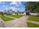 Well-maintained home with dark trim, a landscaped yard, and an inviting driveway leading to the garage at 7331 Blue Jacket W Pl, Winter Park, FL 32792