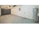 Functional garage with painted floor and block walls, showing the door, utilities and storage potential at 7331 Blue Jacket W Pl, Winter Park, FL 32792