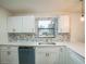 Well-lit kitchen with modern cabinets, tiled backsplash, stainless steel sink, and a view of the outdoors at 7331 Blue Jacket W Pl, Winter Park, FL 32792