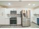 Bright kitchen featuring stainless steel appliances, white cabinets, updated backsplash, and ample counter space at 7331 Blue Jacket W Pl, Winter Park, FL 32792