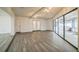 Spacious living room with modern gray wood flooring, white walls, and natural light from sliding glass doors at 7331 Blue Jacket W Pl, Winter Park, FL 32792