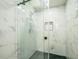Walk-in shower featuring rainfall showerhead, glass enclosure, sleek fixtures, and stylish marble tile at 7331 Blue Jacket W Pl, Winter Park, FL 32792