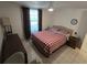 Bedroom showcasing neutral walls, tiled floor, window with dark curtains, and a comfortable bed at 4213 E Michigan St # 4213, Orlando, FL 32812