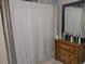 Bathroom featuring a shower behind a curtain and vanity with mirror at 6971 Pompeii Rd, Orlando, FL 32822