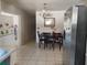 Cozy dining area with a wooden table set, tiled floors, and access to kitchen at 6971 Pompeii Rd, Orlando, FL 32822