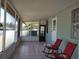 Enclosed porch area with tiled flooring, seating, and access to the interior and exterior at 6971 Pompeii Rd, Orlando, FL 32822