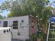 Exterior view of a weather beaten shed featuring peeling paint and some greenery at 6971 Pompeii Rd, Orlando, FL 32822