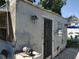 Exterior view of a weather beaten shed featuring peeling paint, a patio, and green space at 6971 Pompeii Rd, Orlando, FL 32822