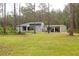 View of home showcasing the attached carport with driveway and lawn at 10411 County Road 474, Clermont, FL 34714