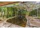 A screened-in backyard pool surrounded by greenery and foliage at 418 W Holly Dr, Orange City, FL 32763