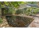 Backyard pool featuring a screened-in enclosure and lush landscaping at 418 W Holly Dr, Orange City, FL 32763