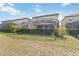 Backyard featuring a screened pool, lush landscaping, and a well-maintained lawn at 5545 Misty Oak Cir, Davenport, FL 33837
