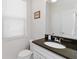 Bright half bathroom with a granite countertop, sleek fixtures and a framed mirror at 5545 Misty Oak Cir, Davenport, FL 33837