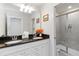 Bathroom featuring a double vanity with black countertop, large mirror, and glass door walk-in shower at 5545 Misty Oak Cir, Davenport, FL 33837