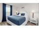 Comfortable bedroom featuring a plush bed, a window with blue curtains, and side tables with lamps at 5545 Misty Oak Cir, Davenport, FL 33837